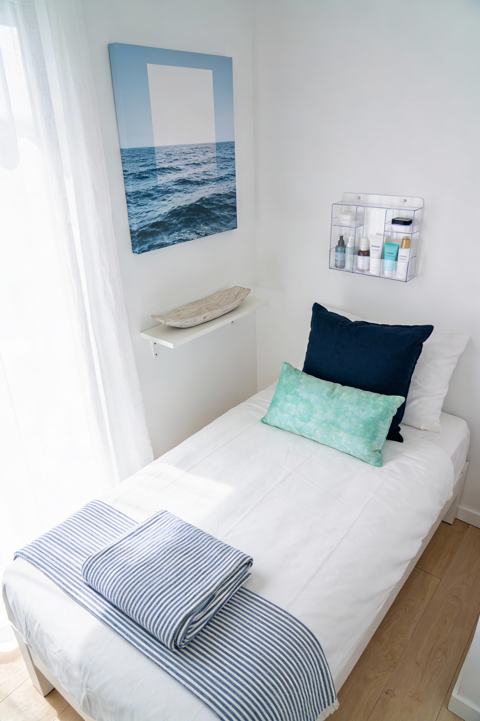 Overhead wide shot of a Coastal Clean Escape hostel bed setup: crisp white bedding with a neatly folded blue-and-white s
